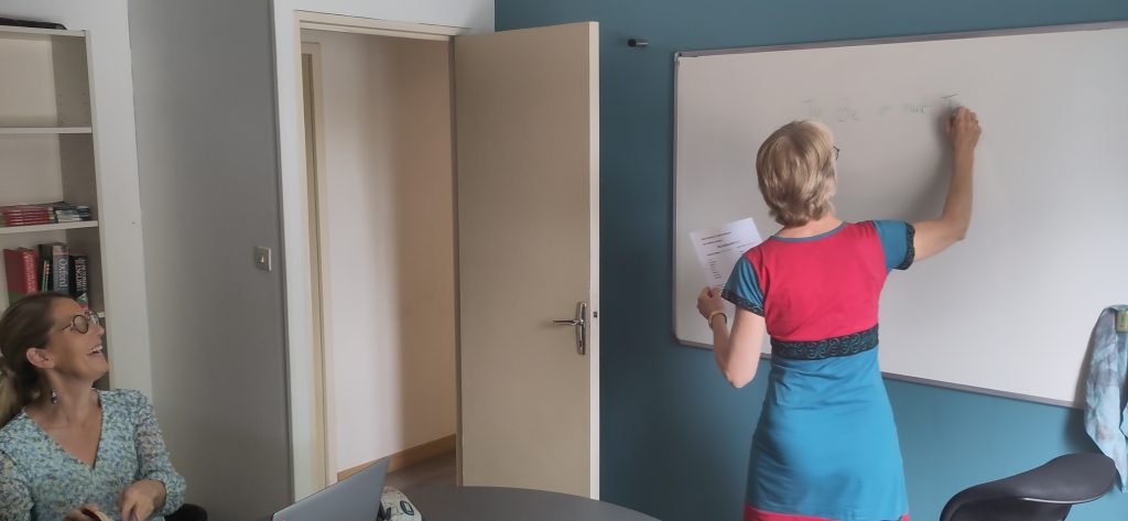 Cours d’anglais Alpha Langues : formatrice au tableau, stagiaire souriante